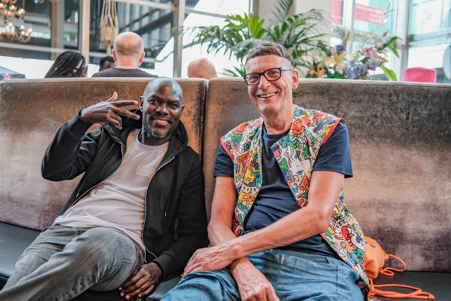 Twee mannen zitten samen op een bank in een ontspannen gesprek