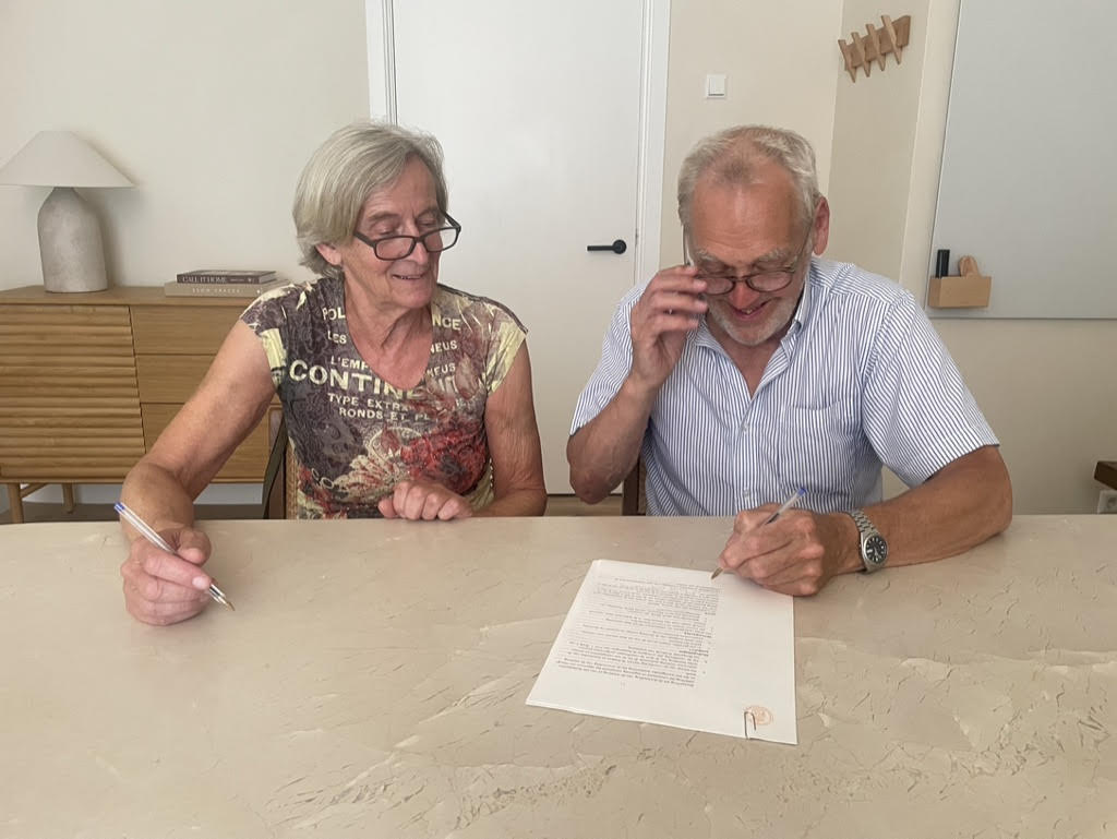 Twee oprichters ondertekenen de oprichtingsakte aan tafel