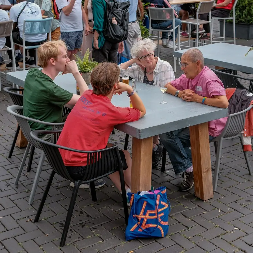 Drie personen op een bankje in gesprek